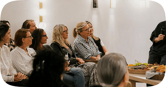 Kathleen Quinn engaging with a seated audience during a workshop, highlighting her role as a speaker and coach guiding professional women in leadership and transition.
